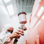 Close,Up,Of,Paint,Spray,Gun,,Worker,Painting,A,Car