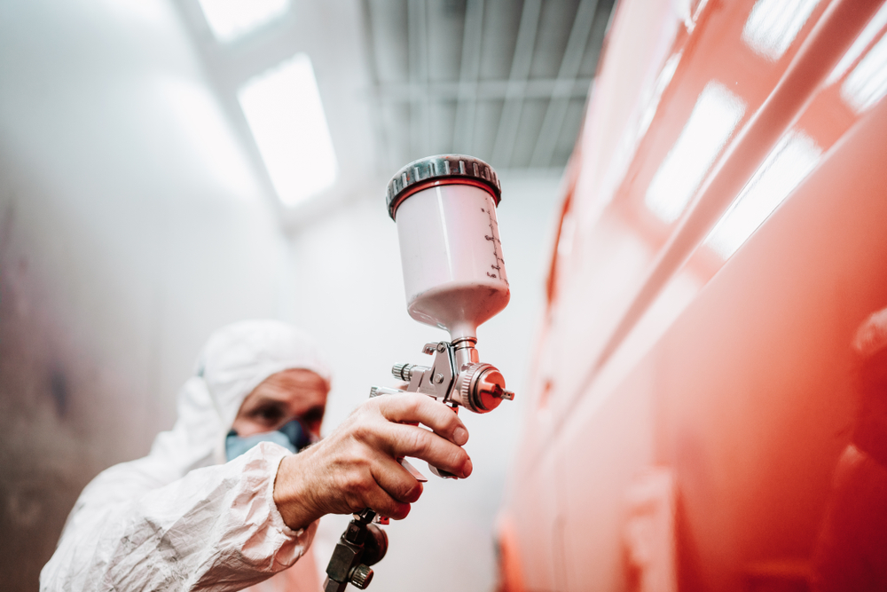 Close,Up,Of,Paint,Spray,Gun,,Worker,Painting,A,Car